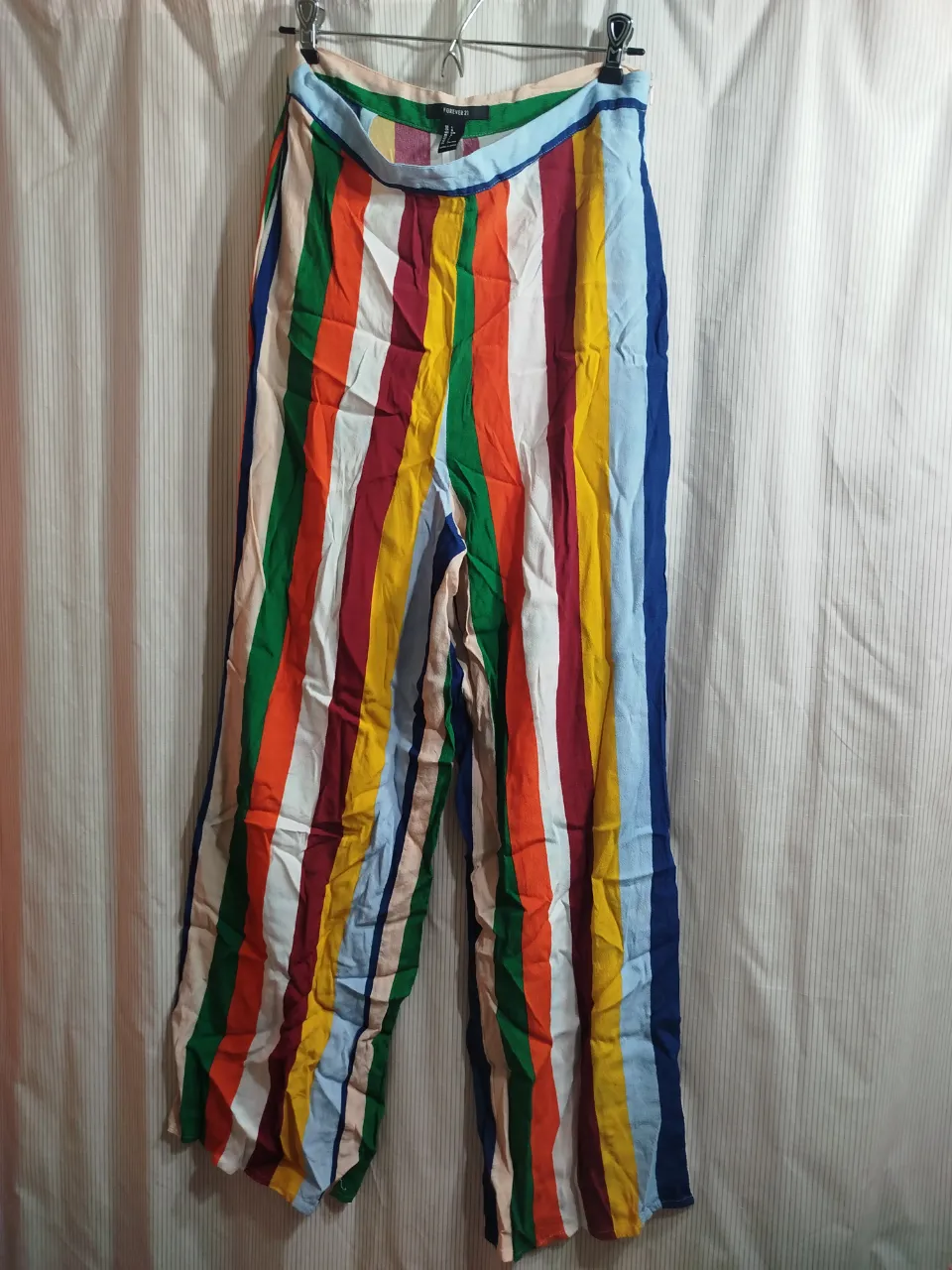 Pantalón suelto de mujer con estampado a rayas multicolores. Talle L. Ideal para un look casual y fresco.