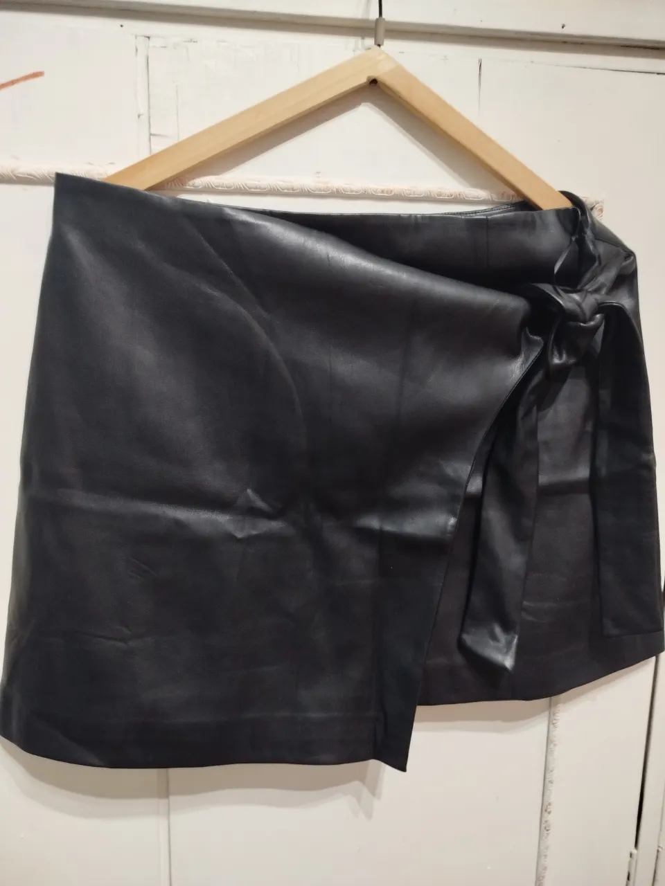 Pollera de cuero sintético negra con detalle de lazo en la cintura. Talle XL, ideal para un look moderno y sofisticado. La compré online en España y no la usé nunca porque no me queda:( Es de la marca MNG, excelente calidad!