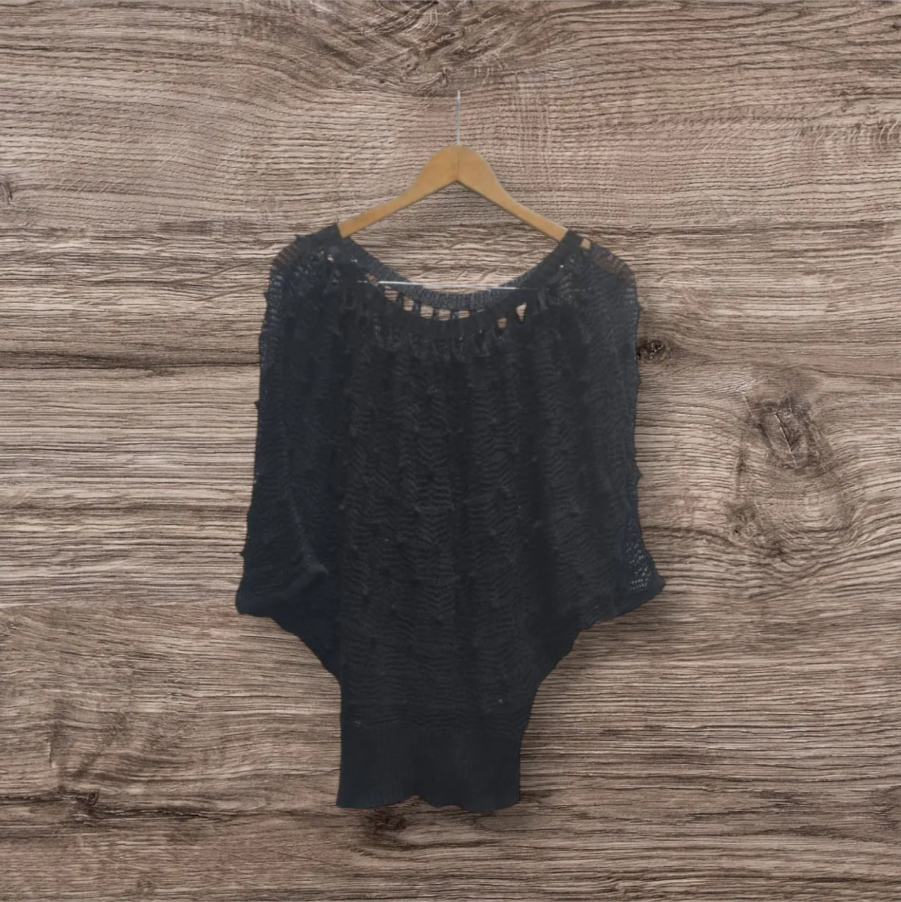 Sweater largo de tejido calado en color negro, ideal para un look elegante y sofisticado. Perfecto para combinar con diferentes outfits.