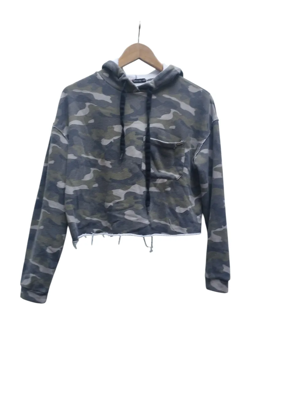 Hoodie crop de camuflado con bolsillo y detalles deshilachados en el ruedo. ¡Un must have para un look canchero!