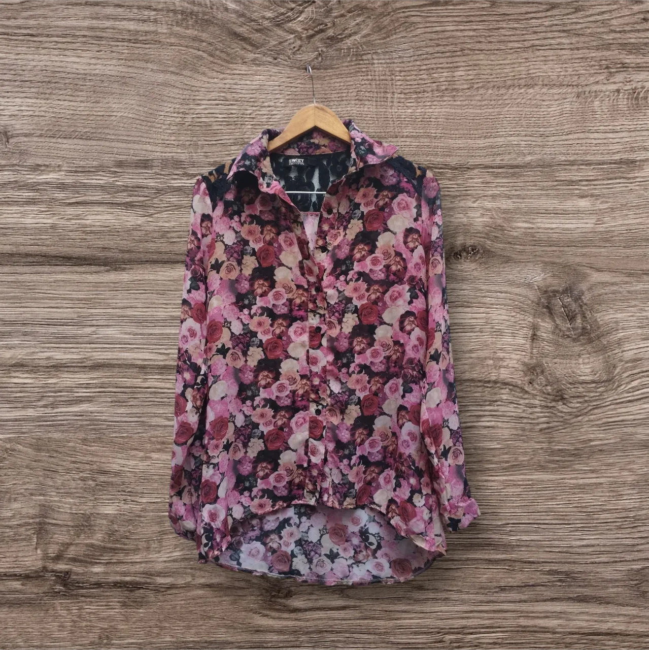 Blusa de mujer con estampado floral en tonos rosas y negros. Diseño con cuello camisero y detalle de encaje en la espalda. Ideal para un look femenino y con estilo.