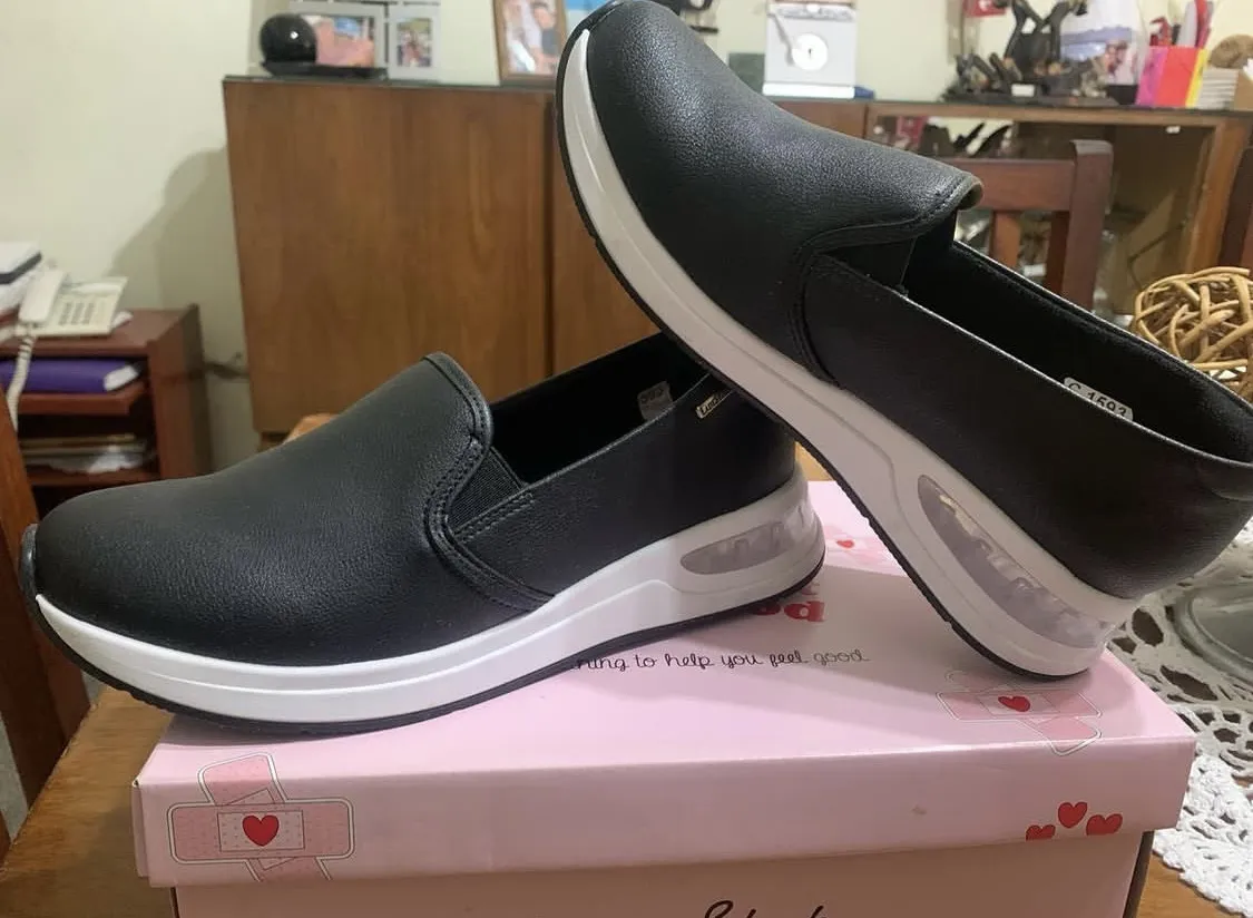 Zapatillas slip on negras con suela blanca y detalles transparentes. Ideales para un look casual y cómodo.