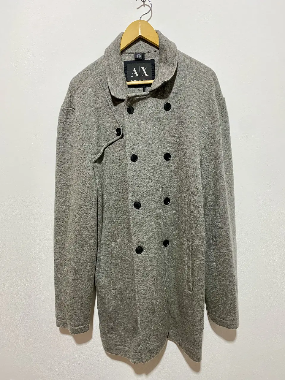 Tapado de hombre Armani Exchange, color gris, con doble botonadura y solapas anchas. Confeccionado en una mezcla de materiales que incluye lana y acrílico, ideal para el invierno. Talle XL. Muy elegante!