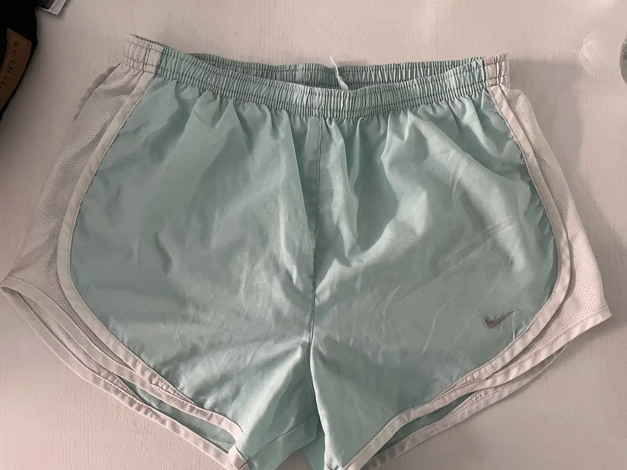 Short deportivo Nike Fit Dry celeste con detalles blancos. Ideal para running y entrenamientos.