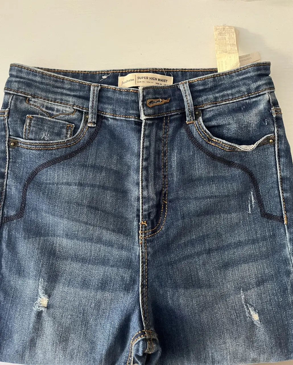 Jeans de mujer tiro alto, con detalles de roturas y diseño moderno. Ideal para un look casual y a la moda.