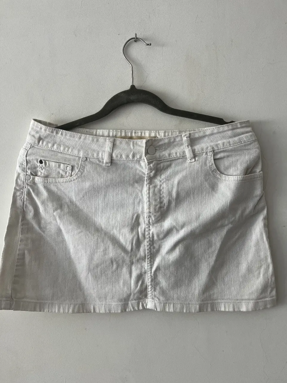 Minifalda de jean blanca, ideal para un look casual y fresco. Perfecta para combinar con diferentes tops y crear outfits versátiles.
