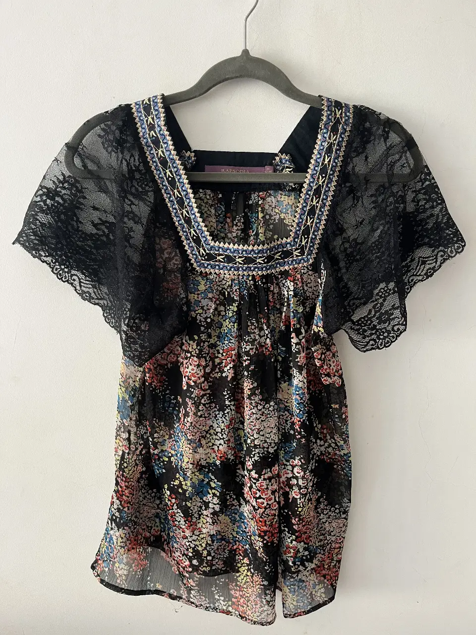 Blusa de mujer con estampado floral y detalles de encaje en las mangas y el cuello. Ideal para un look bohemio y casual.