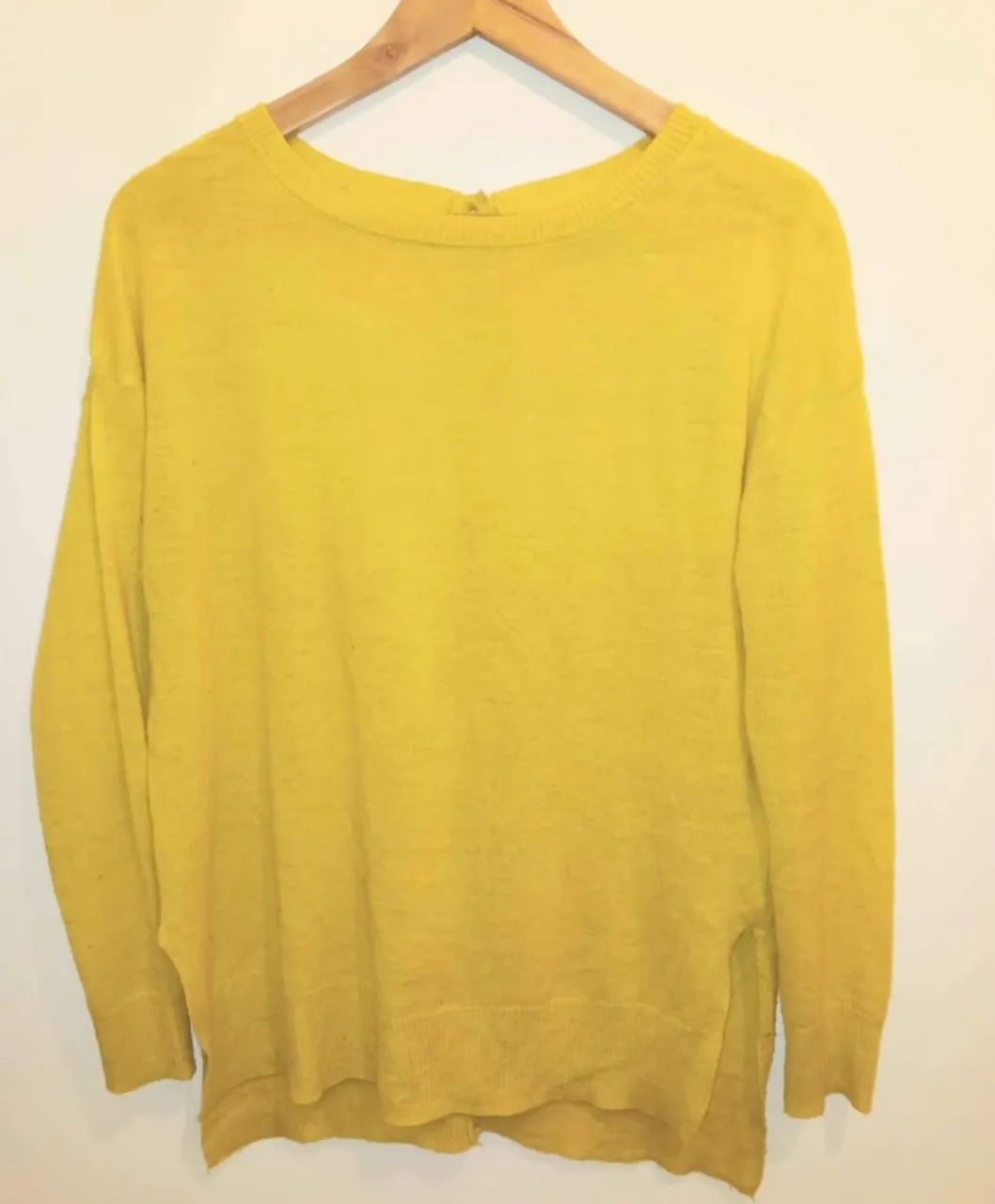 Sweater largo de mujer, color amarillo, con botones en la espalda. Ideal para un look casual y cómodo.