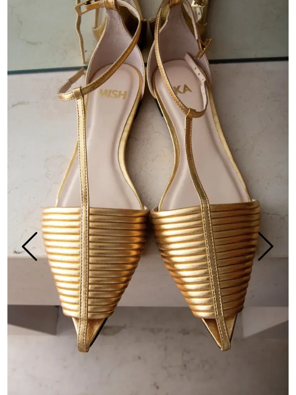 Sandalias doradas súper delicadas y elegantes, con tiras finas y detalle de plumas en la punta. Perfectas para darle un toque chic a cualquier look de fiesta o salida.