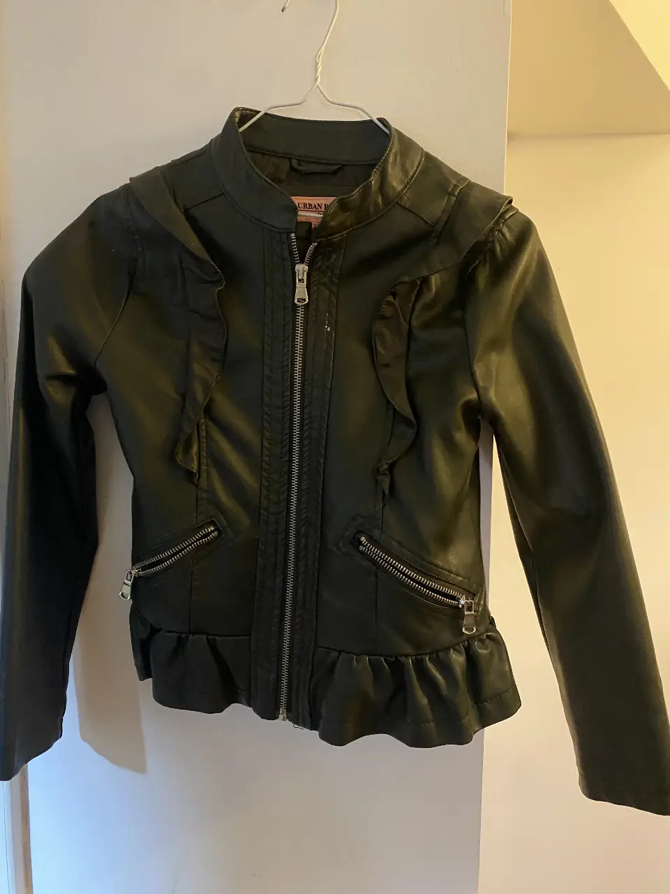 Campera femenina de niña estilo biker de cuero sintético , con detalles de volados y cierre. Marca Urban Republic, talle S/8 (depende de la contextura 9/10). Ideal para un look moderno y canchero.