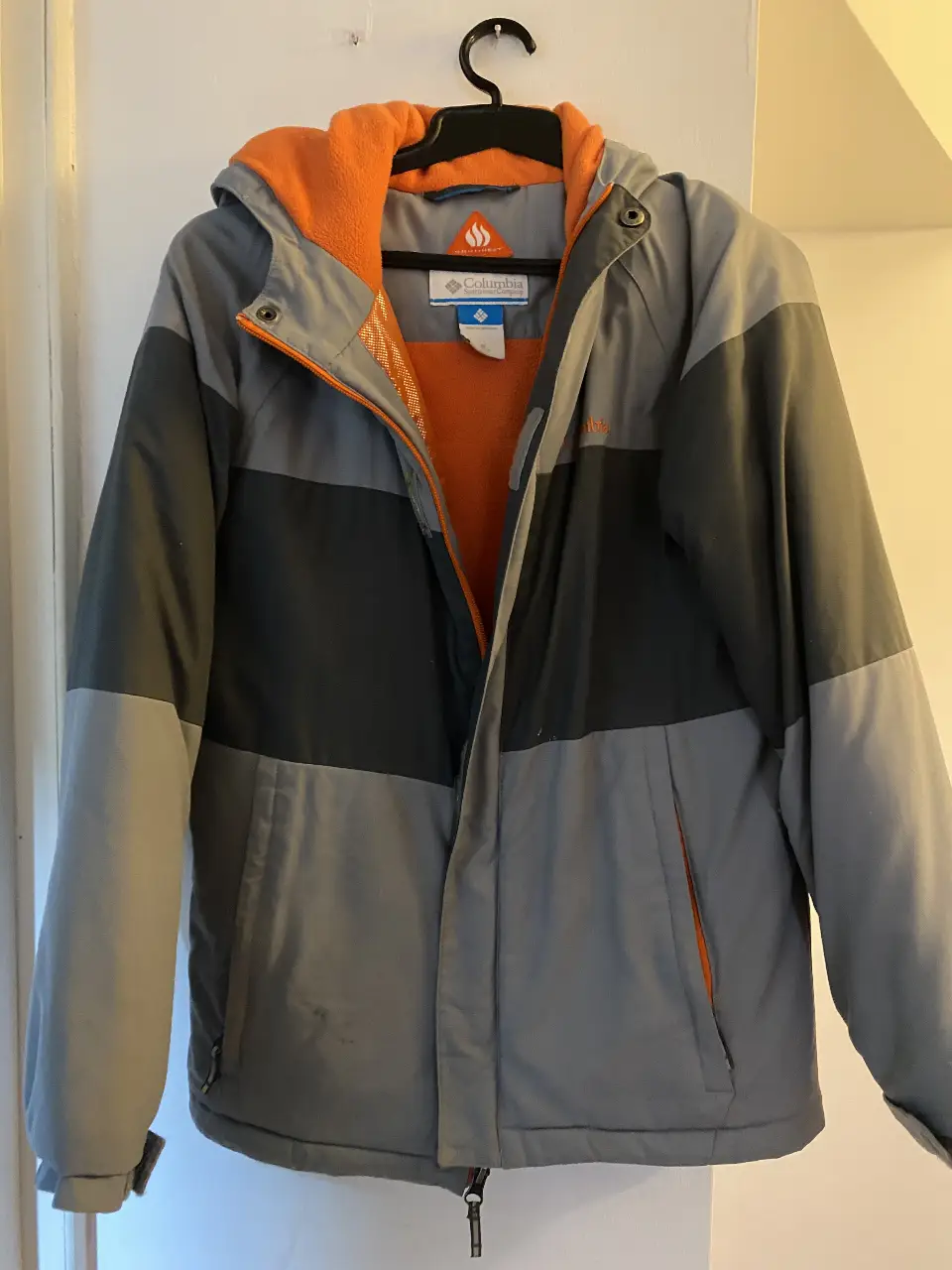 Campera Columbia para hombre, ideal para el invierno. Con capucha, cierre y bolsillos. Talle M (10/12). Color gris con detalles en naranja.