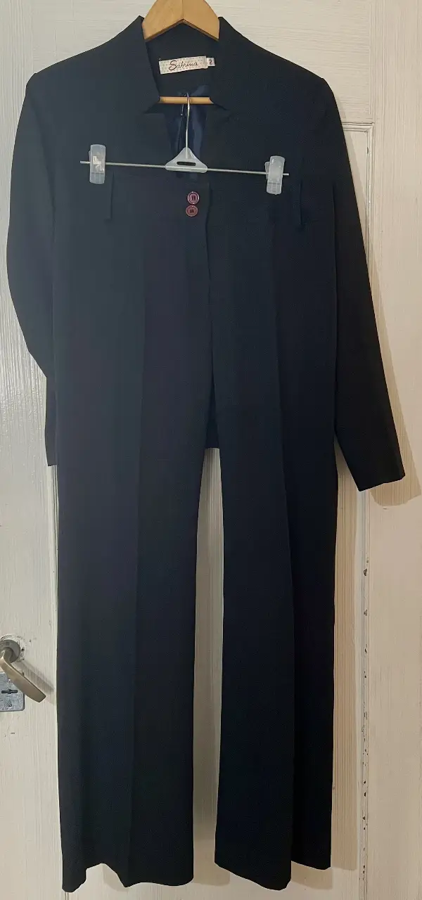 Traje sastrero negro de dos piezas, ideal para un look formal y elegante. Incluye blazer con botones y pantalón de corte clásico.