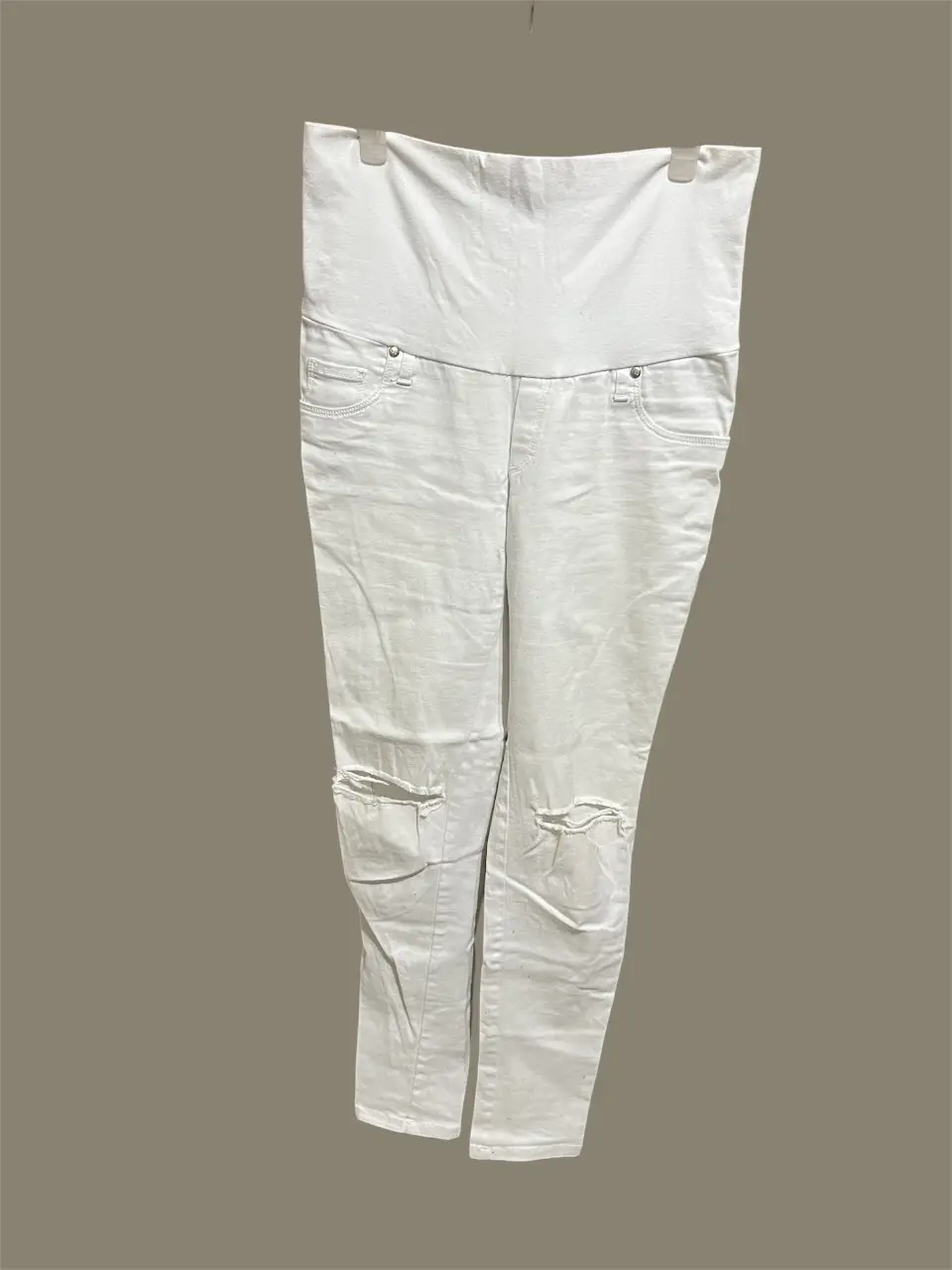 Jean blanco roto de maternidad, con cintura alta y detalles de roturas en las rodillas. Ideal para un look casual y cómodo durante el embarazo.