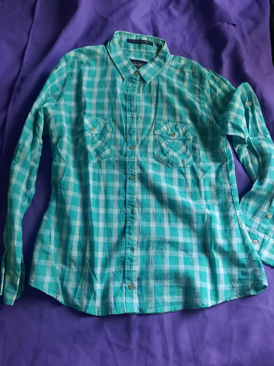 Camisa a cuadros manga larga con dos bolsillos en el frente. Cuello camisero y botones. 