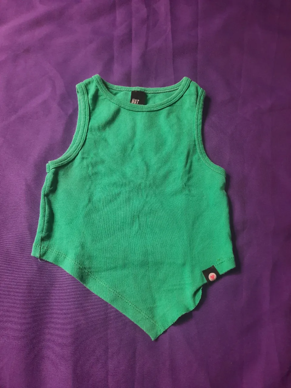 Musculosa verde con un diseño asimétrico y moderno. Ideal para un look casual y canchero. En la segunda imagen se puede notar que se descocio pero no afecta en el uso.