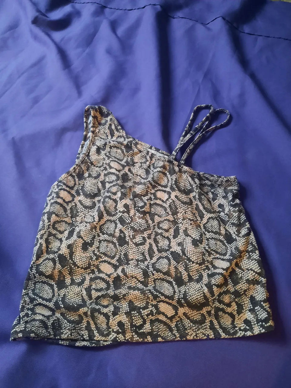 Musculosa con estampa de serpiente y tiras finas. Con un frunce al costado. 