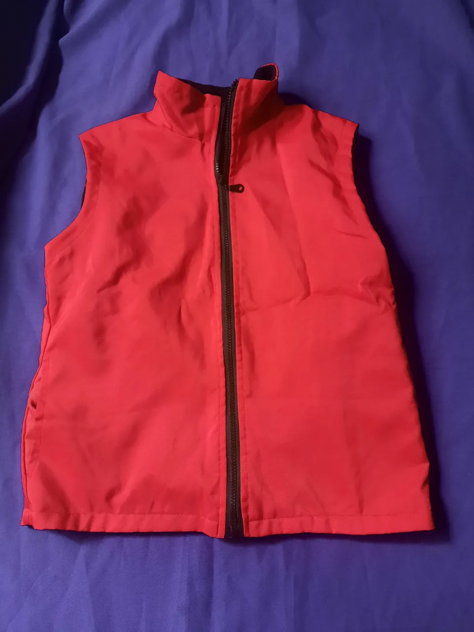 Chaleco rojo con cuello mao y cierre central. Es abrigado.