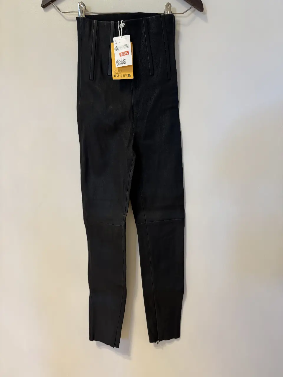 Pantalón de cuero negro de H&M Studio, talle 38 EUR. Con cierre en los tobillos y cintura alta. Ideal para un look elegante y moderno. SIN USO y con etiqueta