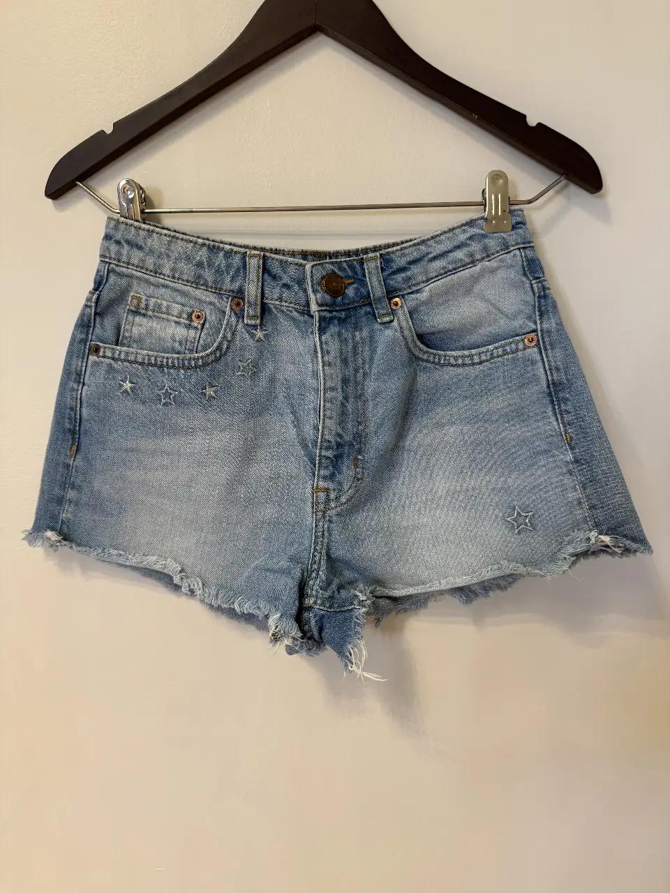 Short de jean de mujer, tiro medio, con detalles de estrellas bordadas y flecos en el borde. De la colección oficial de H&M Coachella.