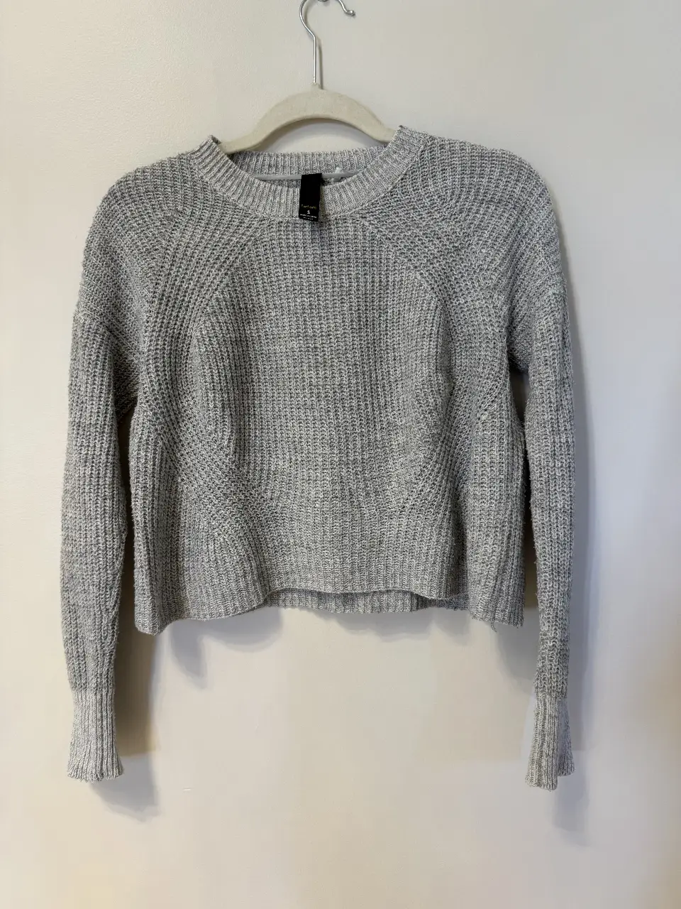Sweater gris de punto, con cuello redondo y mangas largas. Ideal para un look casual y abrigado.