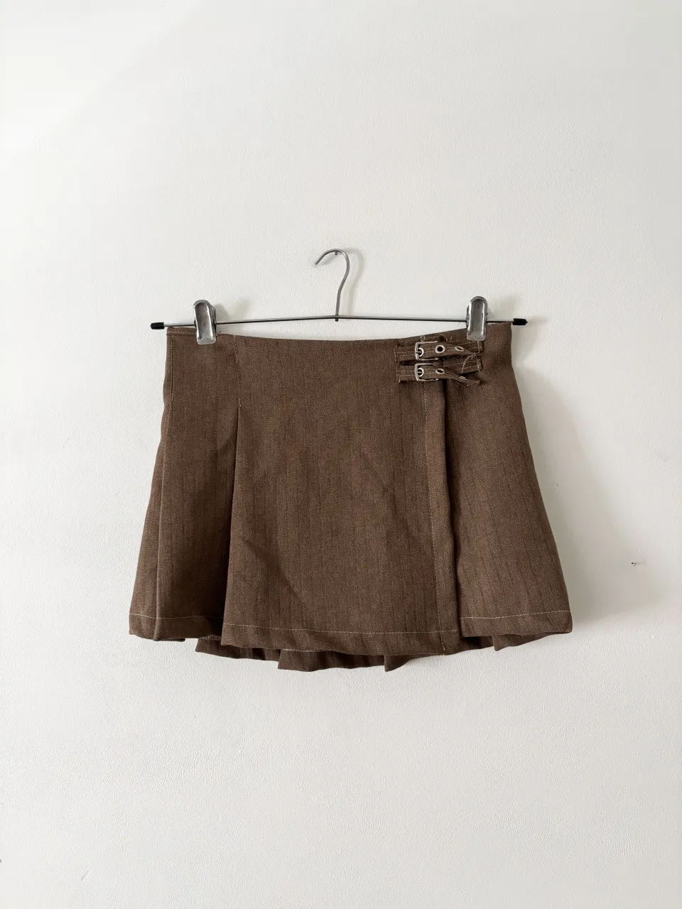 Pollera tableada mini con hebillas🤎 Se abre completa y se engancha con un brochecito interno y las hebillas de afuera. Va del tiro que quieras! Puse cualquier talle, para mi es un XS o S. Mide 35cm y va hasta 37cm. Muy linda sola o con medias abajo!

 // minifalda tablas ganchitos mini marrón zara bershka h&m edikted urban outfitters jaded london  falda polleras cuadrille 