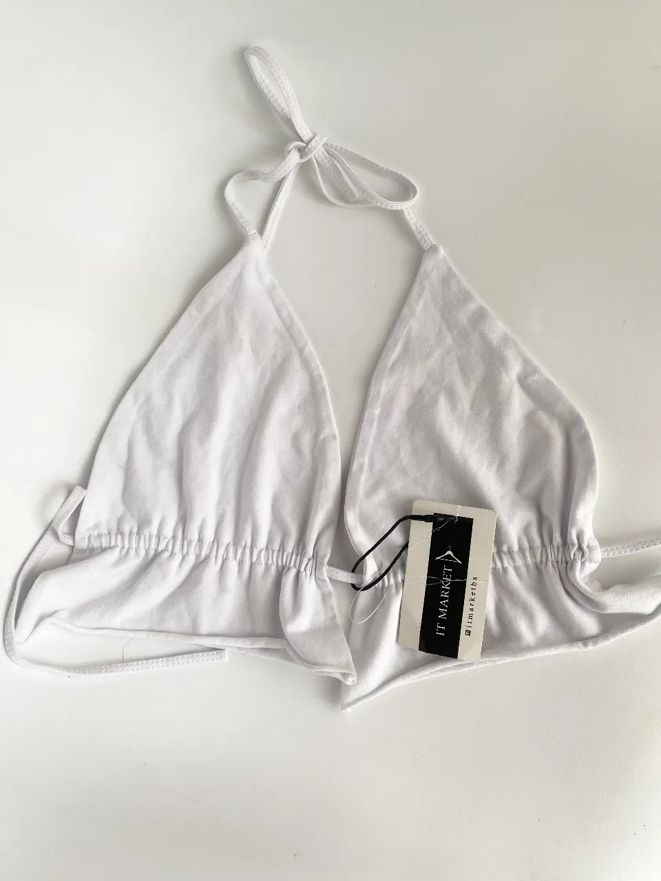 Top  blanco con fruncido y etiqueta de la marca IT MARKET. Los triangulos son regulables, se ata en cuello y espalda a gusto. Puse talle porque me pedía pero puede ir de un 80 a un 90/95. Una bomba para salir! 