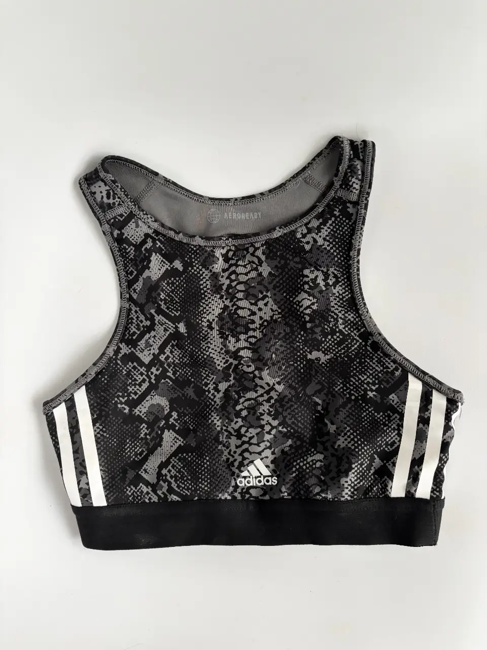 Top deportivo Adidas original con estampado en tonos grises y negros. 2 usos como mucho🖤Diseño con tirantes cruzados en la espalda y el logo de la marca en blanco. Es súper cómodo, elastiza y se amolda a vos. Es ideal 80/85/90