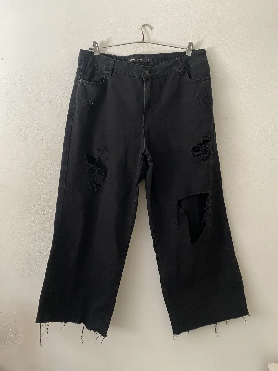 Jeans negro de mujer con roturas en las rodillas y corte ancho Cuesta Blanca. Poco y nada de uso 🖤 Talle 50. Miden 47cm de cintura, 92cm de largo, 51cm ancho  donde empiezan los bolsillos, 56cm ancho donde termina el cierre. Se pueden usar del tiro que quieras, van también tiro bajo baggy! 