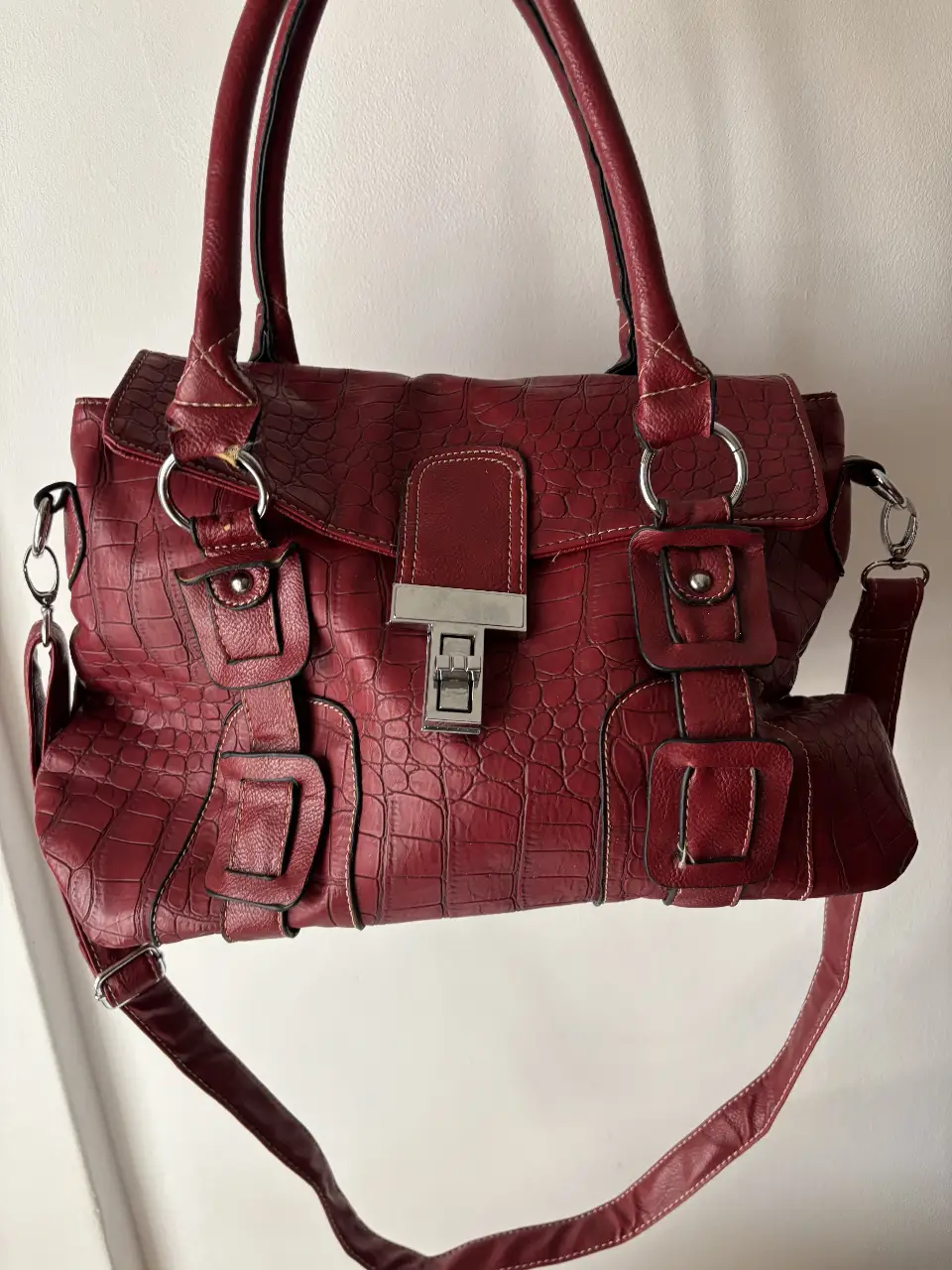 Cartera bordó con textura de cocodrilo, ideal para llevar al hombro o cruzada. Cuero sintetico gruesio, re linda calidad. Cuenta con detalles metálicos plateados y un cierre con solapa. Estilo City Bag, es súper amplia