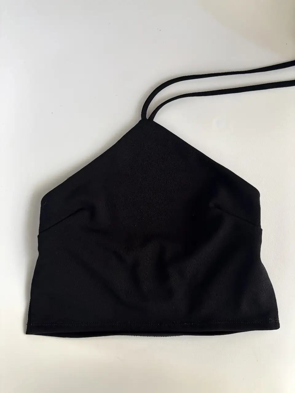 Top negro con diseño halter. Tiene tiras para regular a gusto. Elastiza, ideal 80/85/90