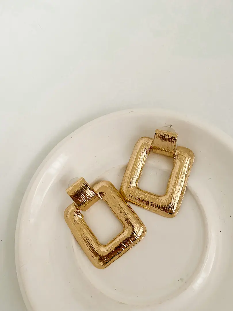 Aros cuadrados dorados nuevos, ideales para darle un toque de elegancia a cualquier look. Perfectos para un evento especial o para el día a día.