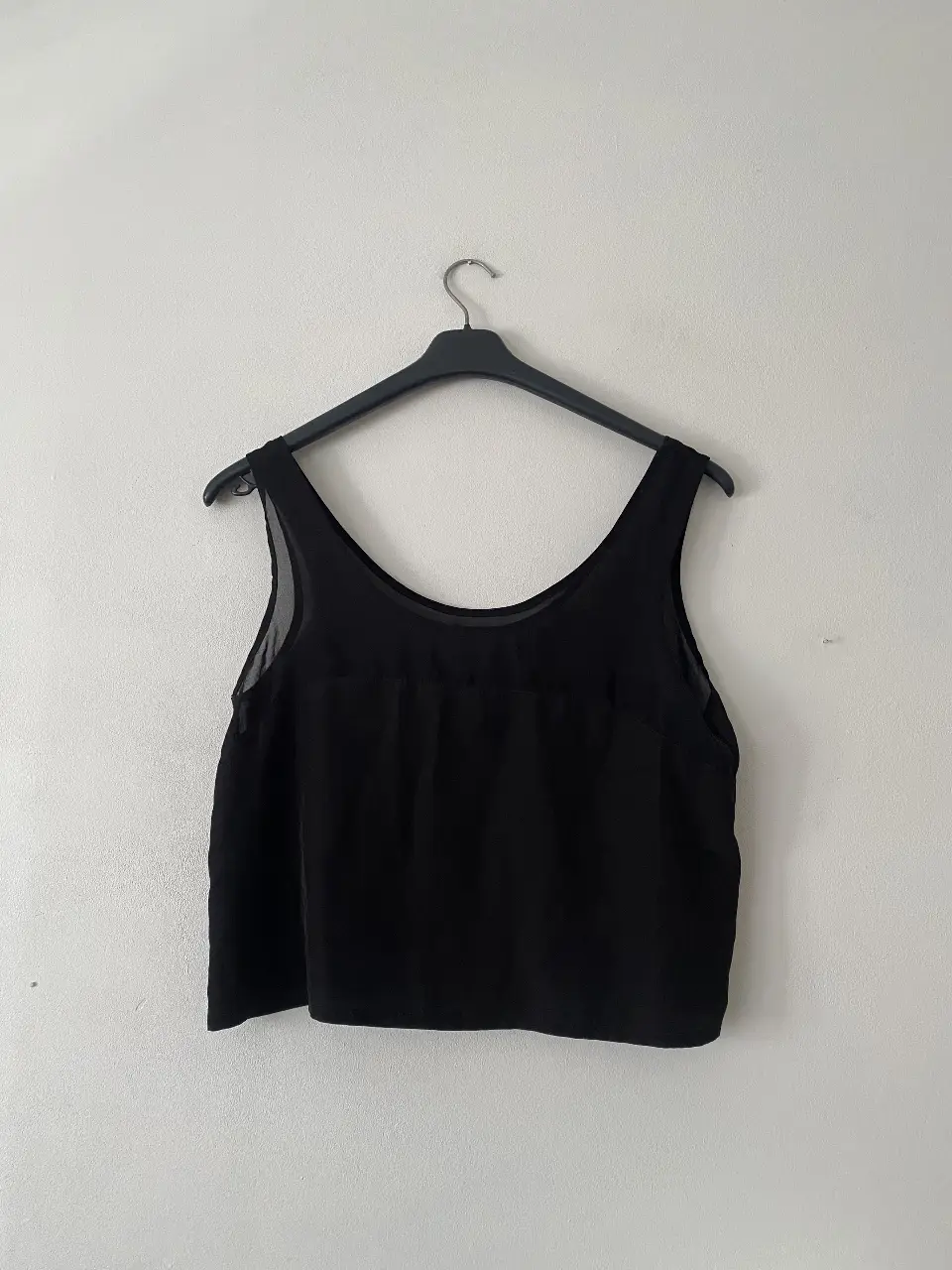 Top negro con detalle de transparencia en la parte superior. Ideal para un look casual o para salir. Marca Complot, talle S.