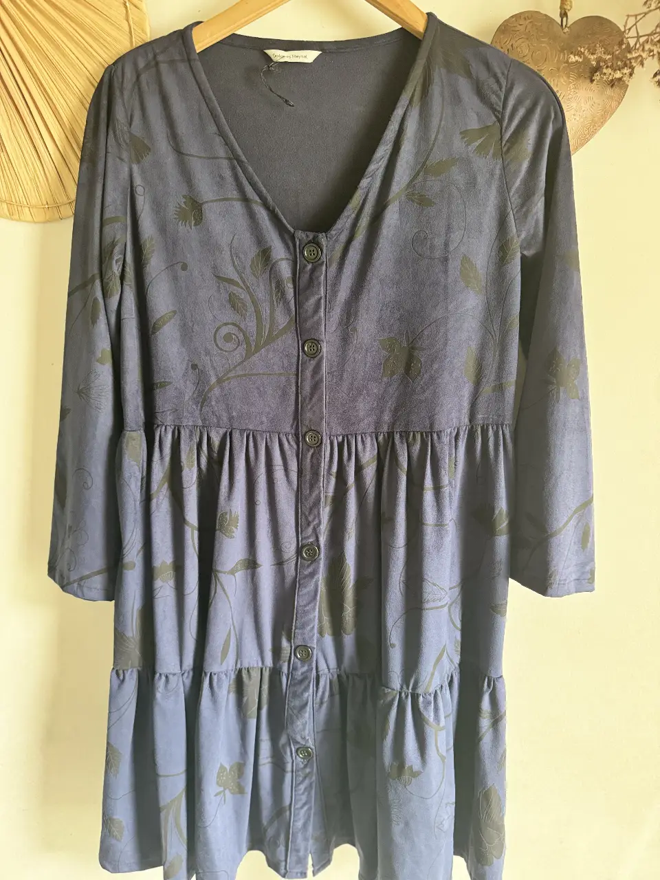Vestido midi azul con estampado floral en negro. Diseño con botones frontales, mangas 3/4 y detalles fruncidos. Ideal para un look casual y cómodo.