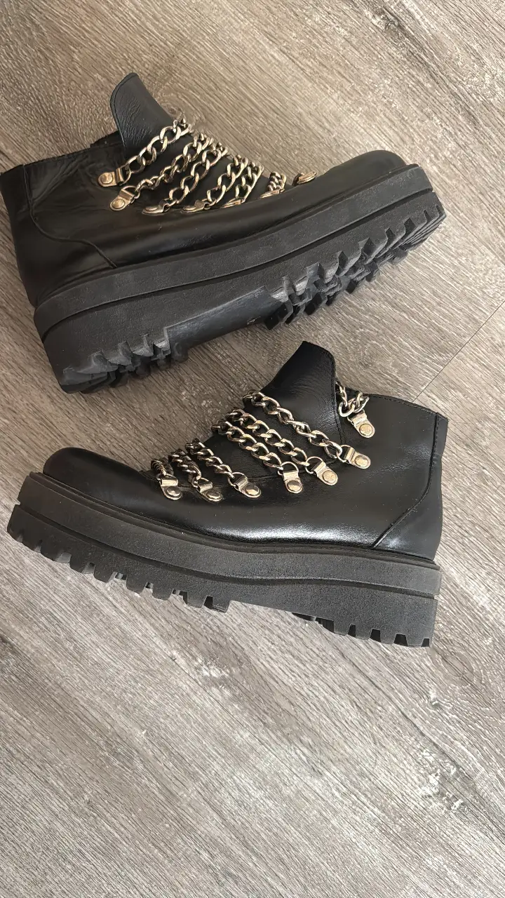 Botines negros con plataforma y detalles de cadenas plateadas. Ideales para un look rocker o streetwear.