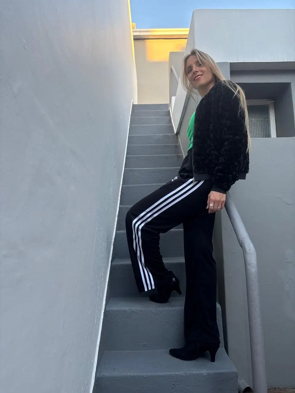 Pantalón deportivo negro con tres tiras blancas en los laterales. Tiro medio, corte recto y holgado. Ideal para un look casual y cómodo.