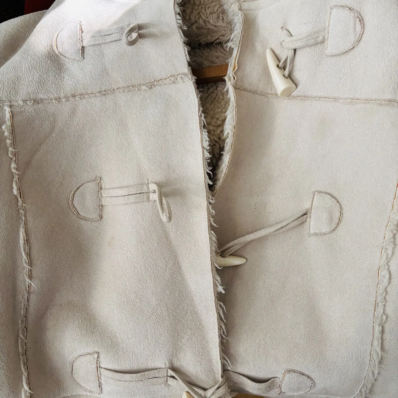 Tapado de mujer estilo duffle coat, color crudo, con capucha y detalles de botones de madera. Ideal para el invierno.