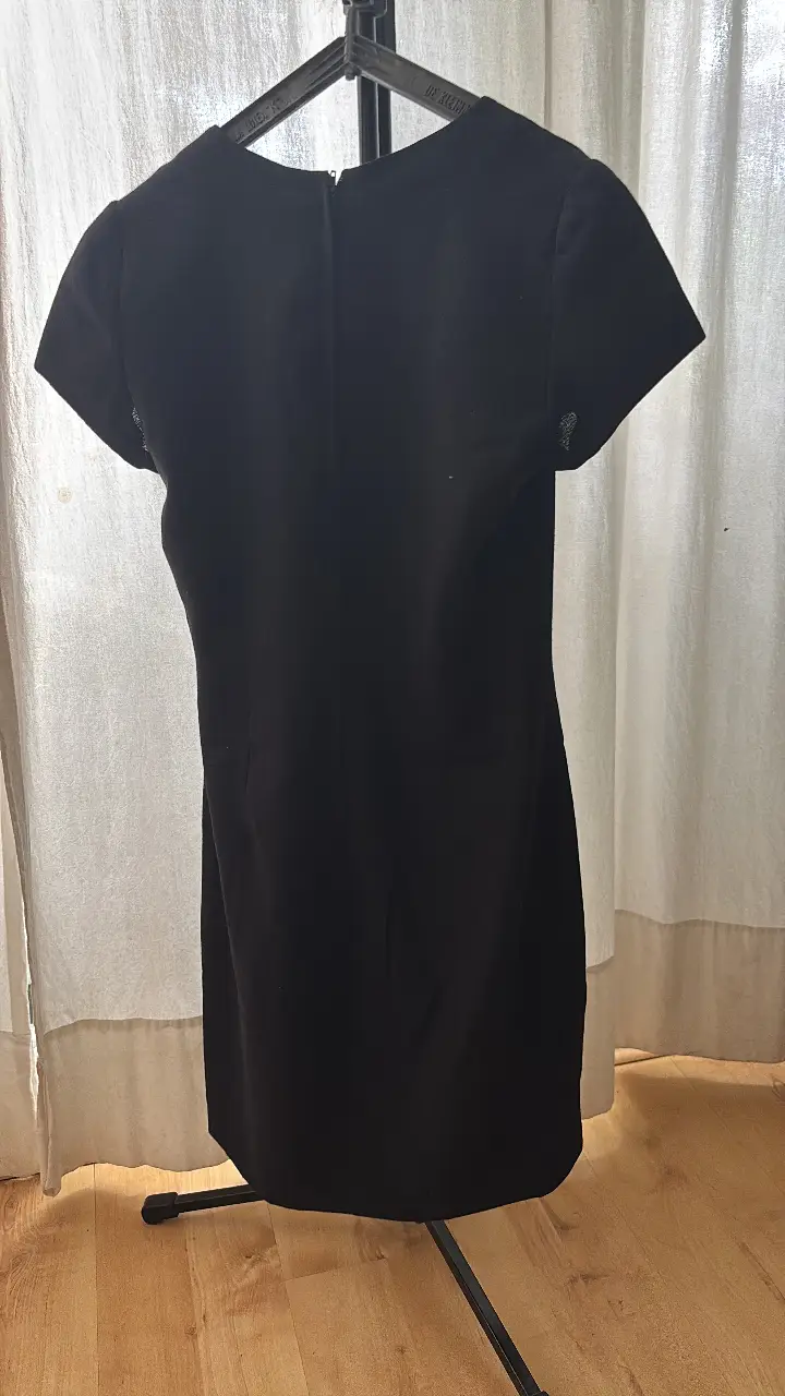 Vestido midi negro de la marca Cristina Morante. Corte recto, con mangas cortas y cierre en la espalda. Ideal para eventos formales o para usar en el trabajo.