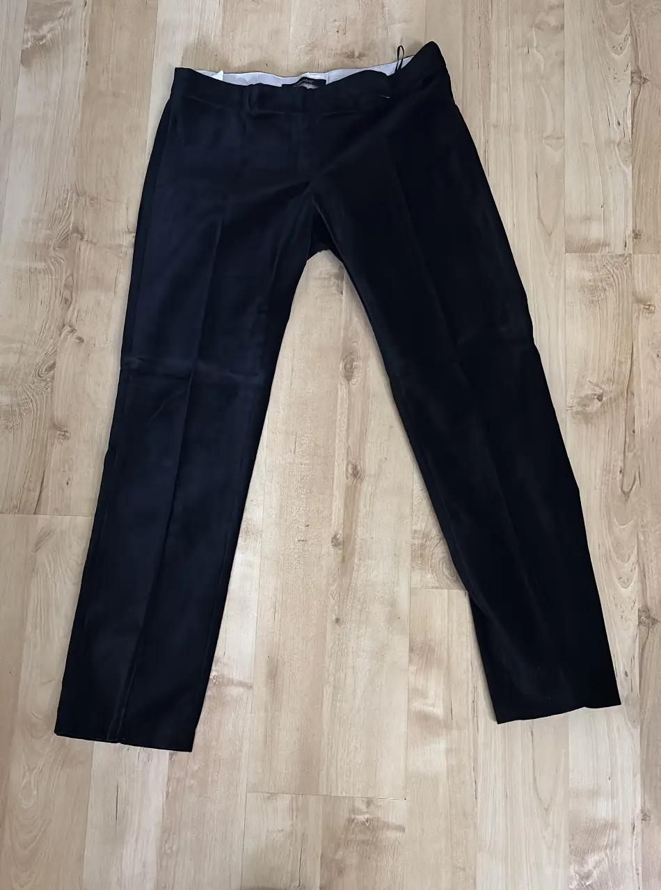 Pantalón sastrero de terciopelo negro, ideal para un look elegante y sofisticado. Perfecto para ocasiones formales o para darle un toque de glamour a tu outfit diario. Marca Chocolate.