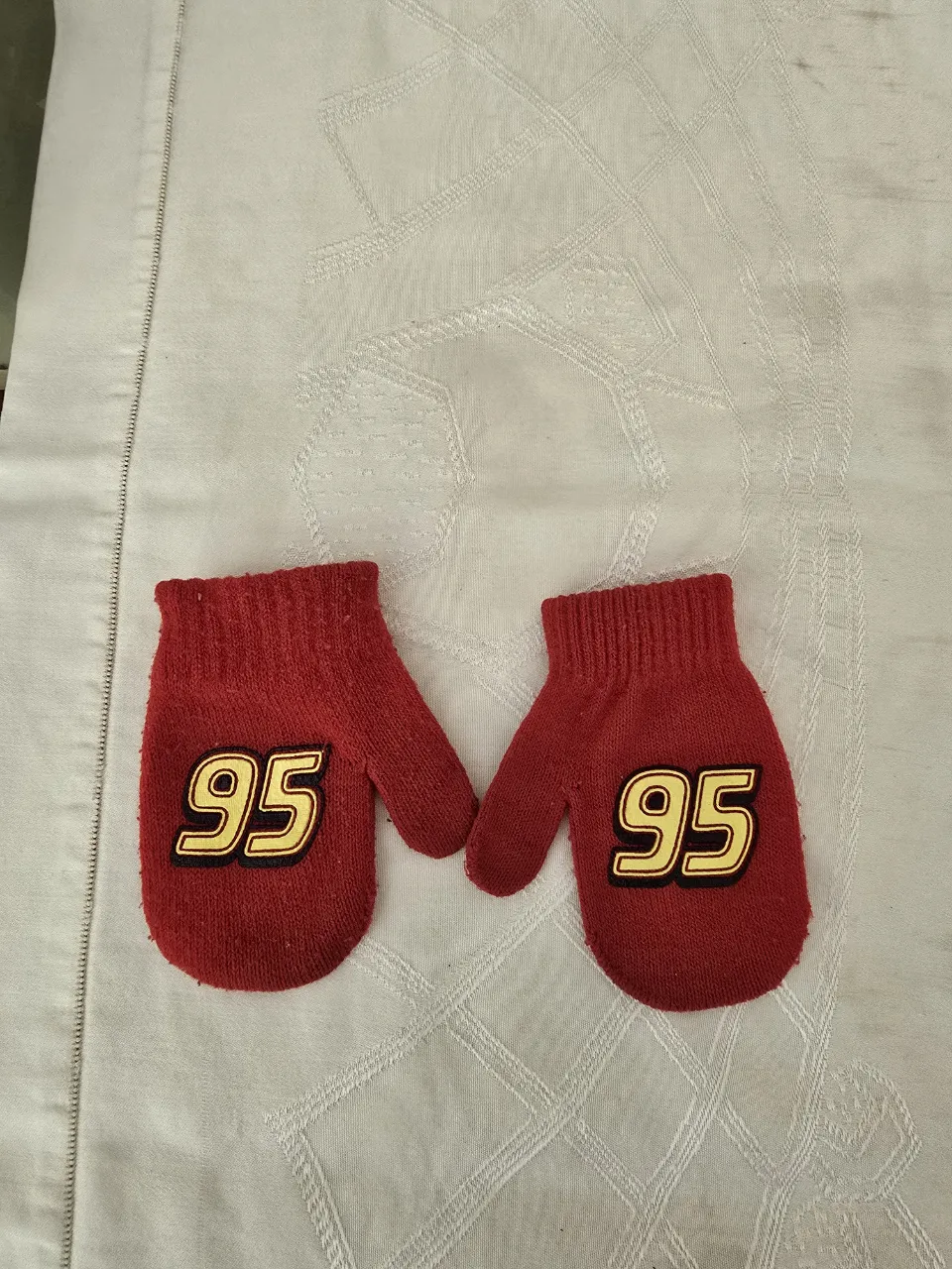 Manoplas rojas con el número 95 en amarillo y negro. rayo mcqueen