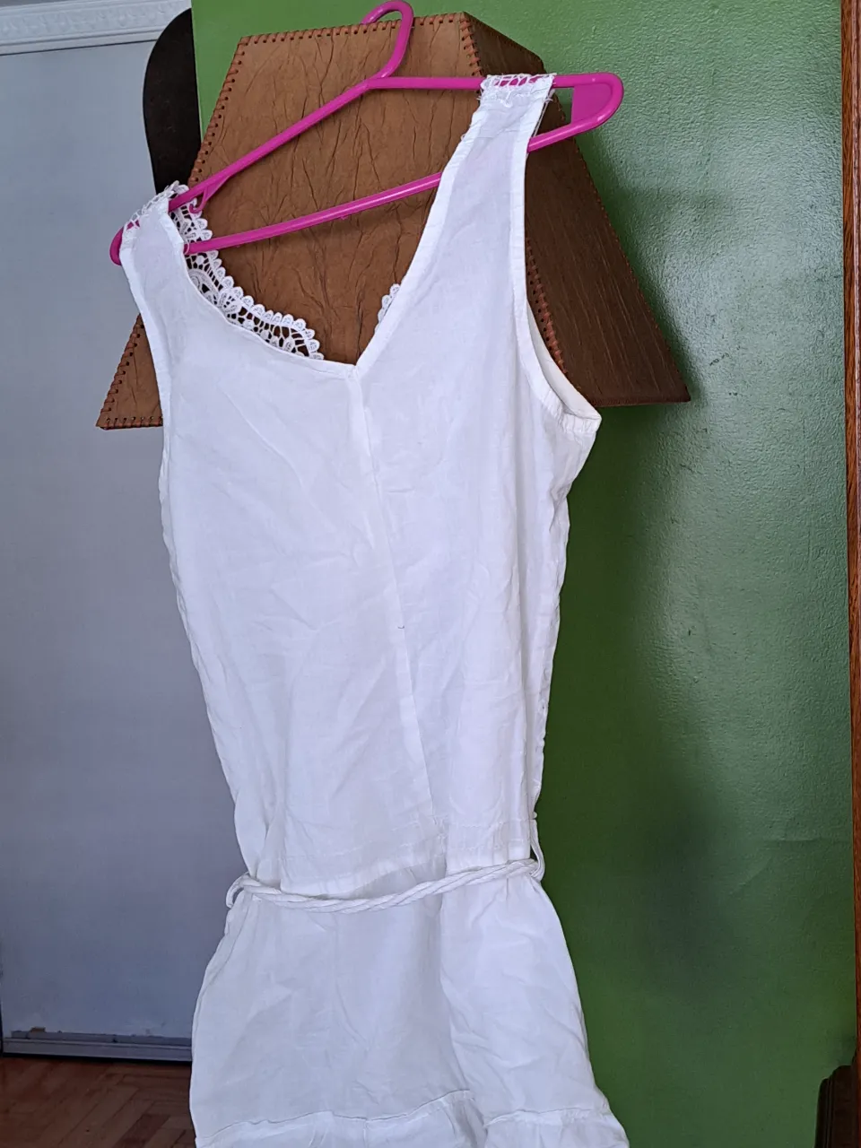 Vestido blanco mini con detalles de encaje en el escote y cintura con cordón. Ideal para un look fresco y femenino.