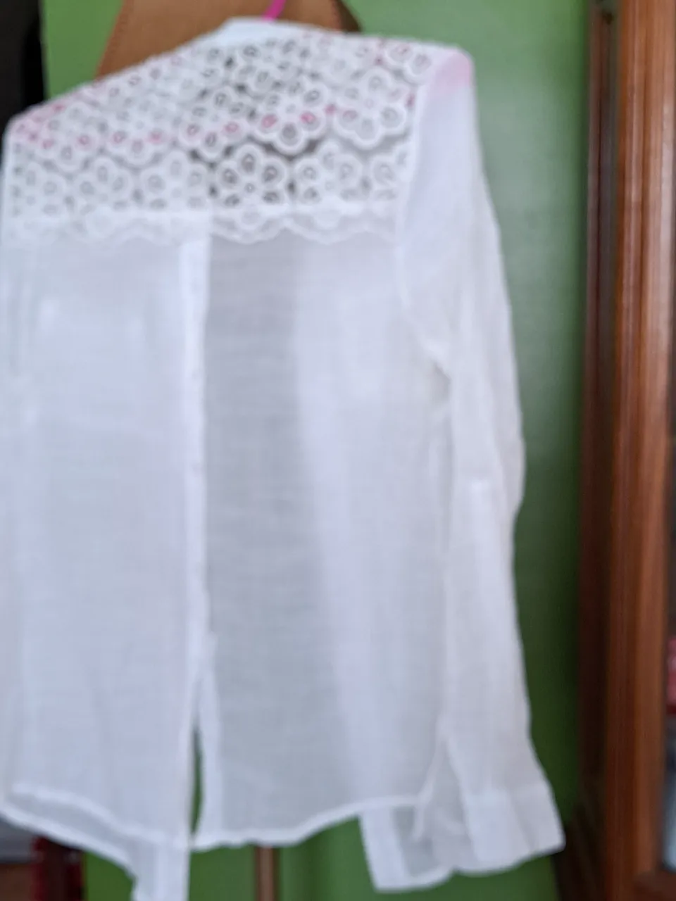 Blusa blanca de mujer con detalles de encaje en el cuello y mangas largas. Ideal para un look elegante y fresco.
