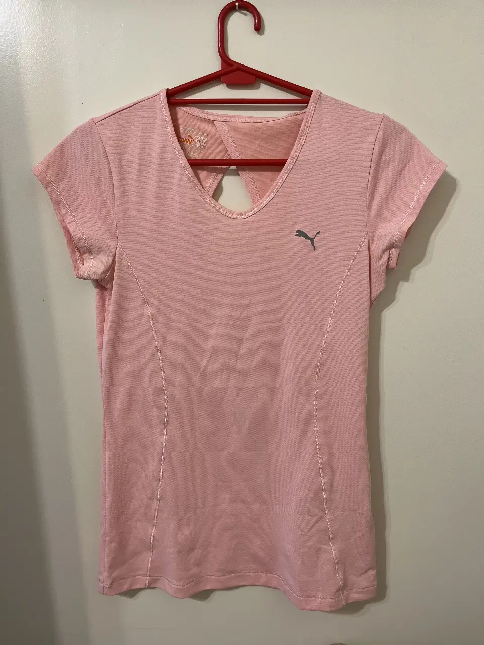 Remera deportiva Puma dry fit rosa, con espalda descubierta y logo de la marca en el frente. Ideal para entrenamientos.