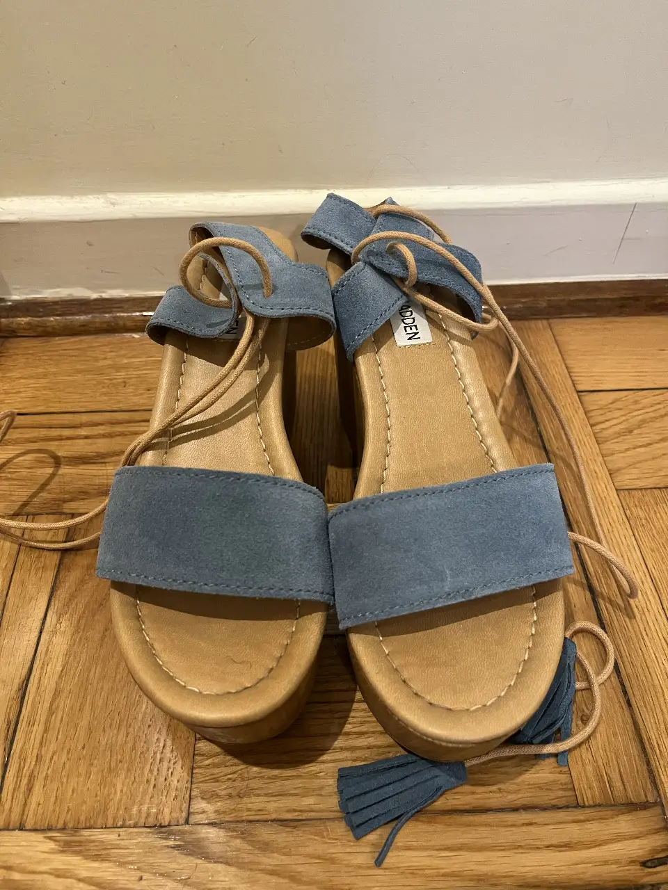 Sandalias de plataforma con tiras para atar al tobillo, de gamuza celeste y base de madera clara. Ideales para un look casual y cómodo.