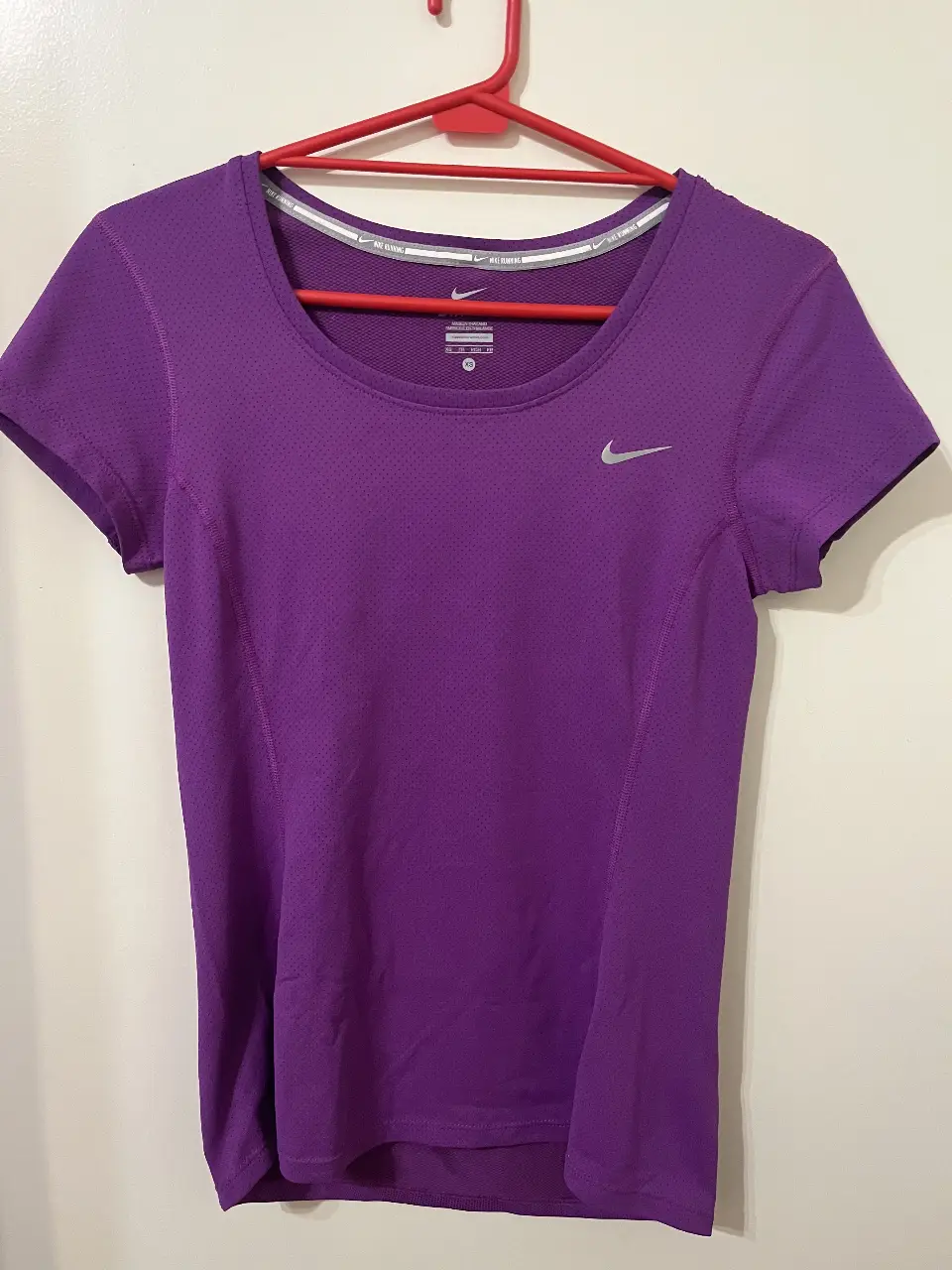Remera running Nike Dri-Fit de mujer, color violeta, talle XS. Ideal para running y entrenamiento.