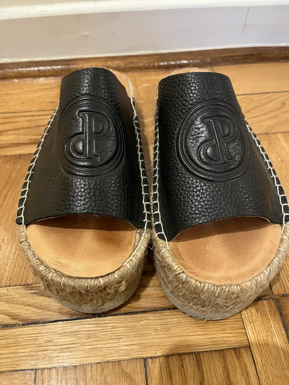Sandalias Prune planas de mujer, color negro, con plataforma de yute y detalle de costura blanca. Diseño con logo de la marca en relieve.