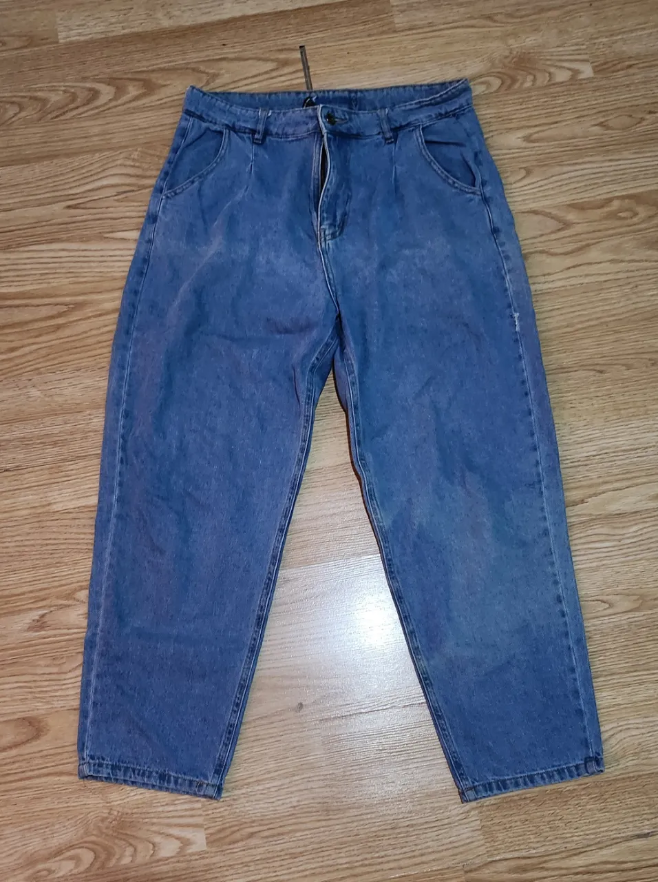 Jeans tiro alto, corte recto y ancho. Lavado clásico, con bolsillos delanteros y traseros. Tiene dos manchas descolorizadas imperceptibles en persona en la parte trasera. (cintura: 43cm ; largo:96cm ; cadera 51cm)