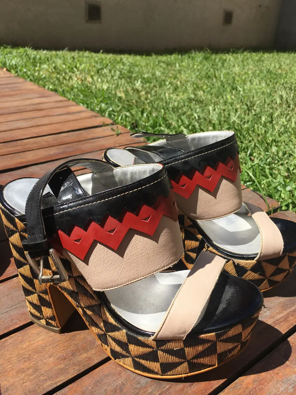 Sandalias de plataforma con diseño geométrico y detalles en negro, rojo y beige. Ideales para un look moderno y llamativo.