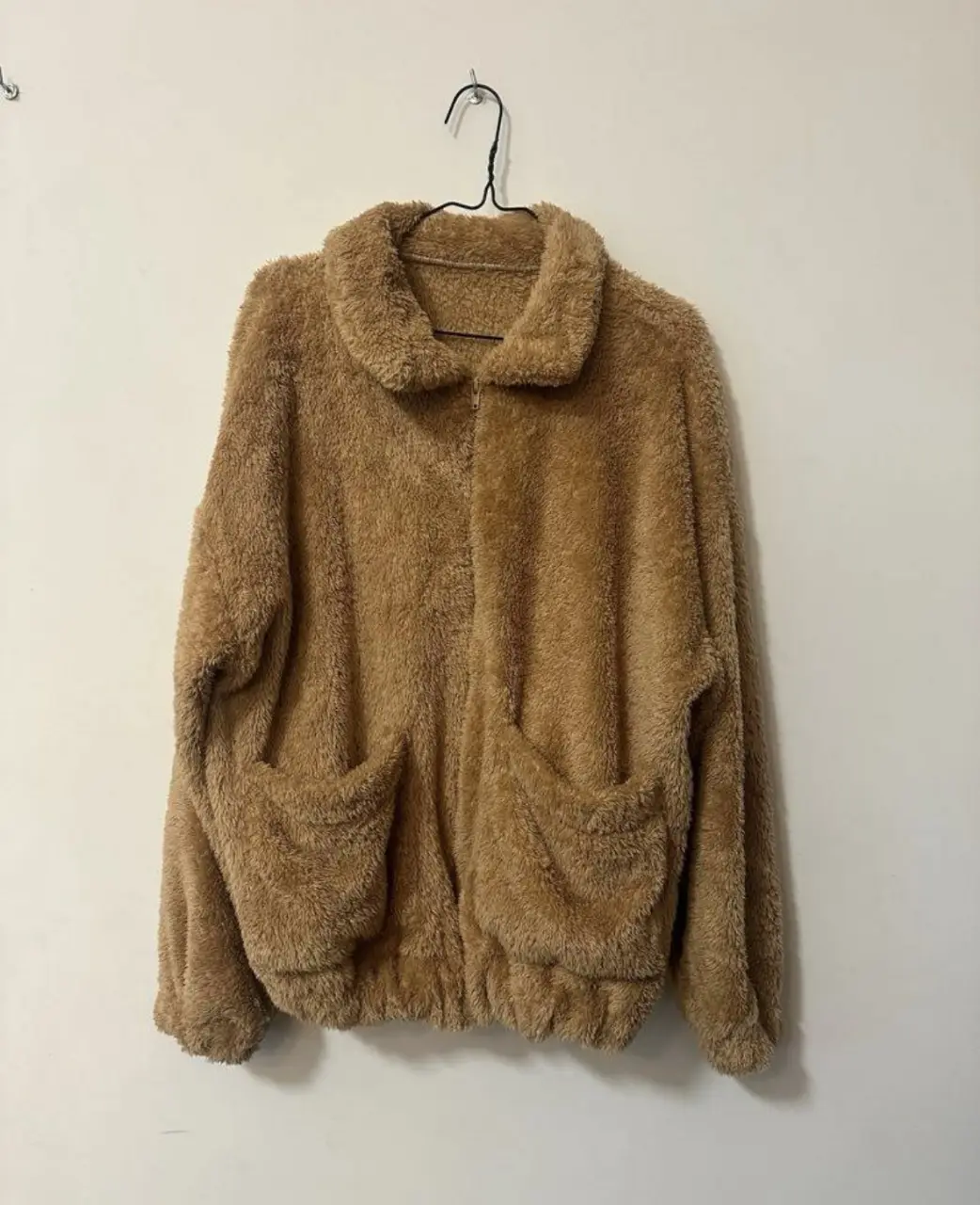 Campera de abrigo estilo teddy bear, con un tacto suave y abrigado. Posee dos bolsillos delanteros amplios y un cierre frontal. Ideal para un look casual y cómodo en los días fríos. Marca: Chola