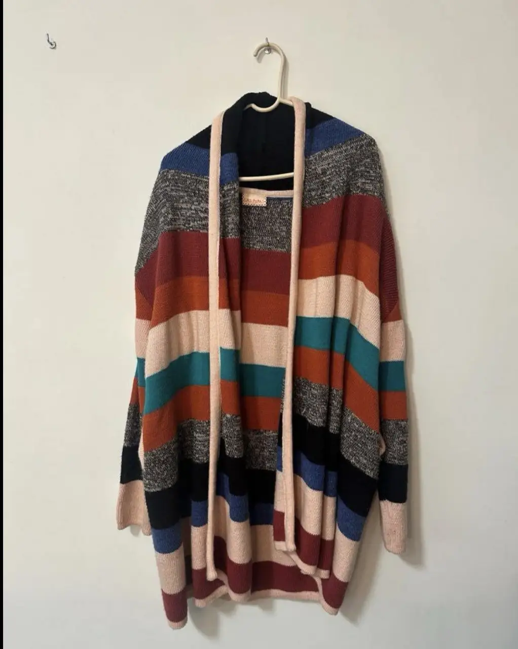 Cardigan de mujer con diseño a rayas en tonos cálidos. Ideal para un look casual y abrigado. Confeccionado en tejido suave y cómodo, perfecto para el invierno.