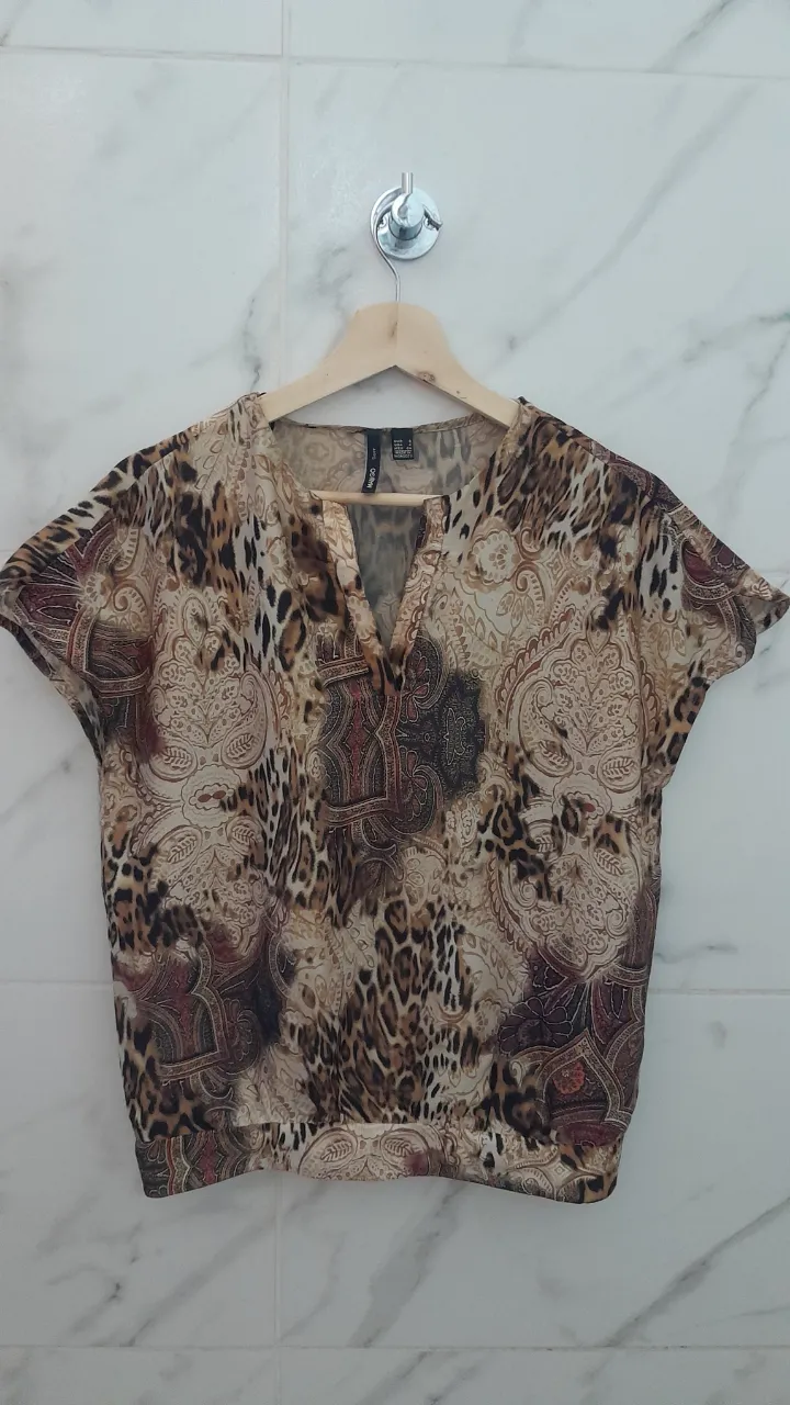 Blusa estampada con motivos de animal print y paisleys. Posee escote en V y mangas cortas. Ideal para un look casual y canchero.